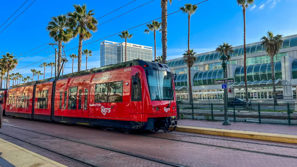 The iconic red San Diego trolley at a station.