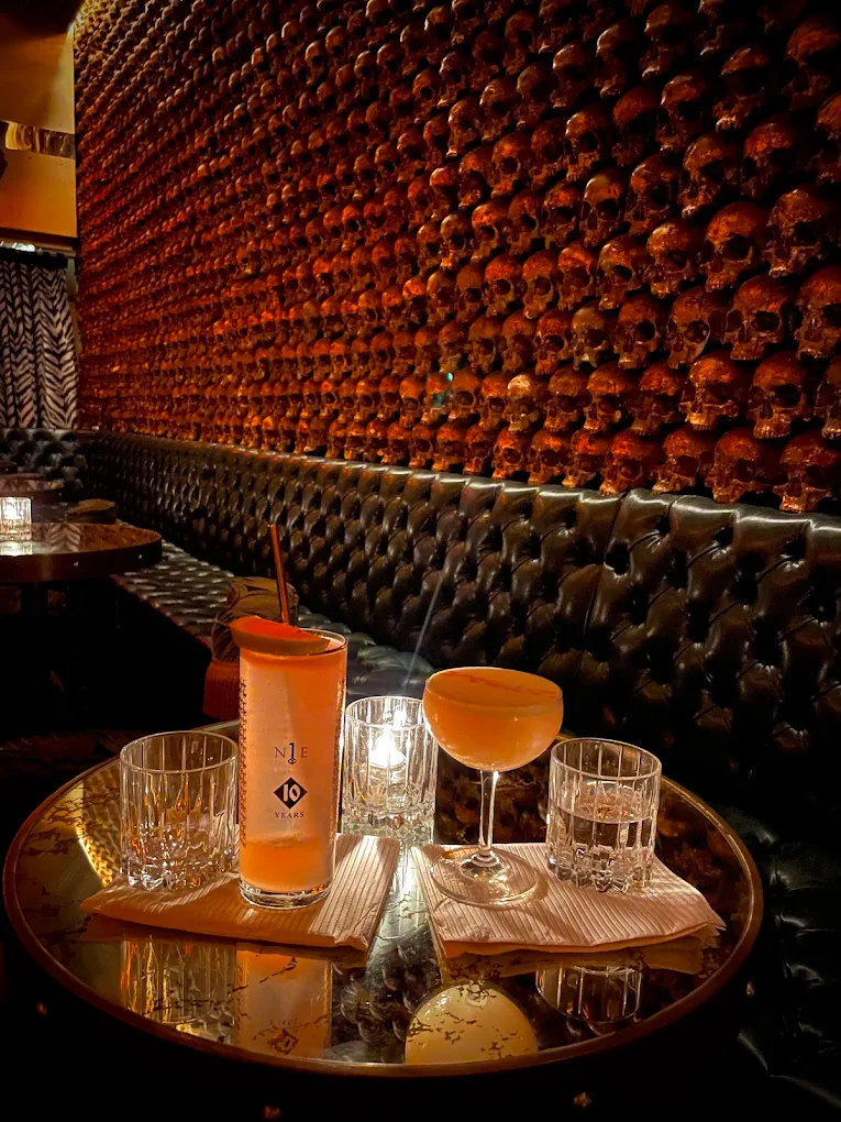 A bartender skillfully crafting a sophisticated cocktail at a stylish, dimly lit bar.
